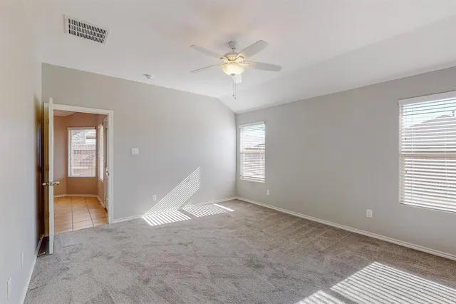 a view of an empty room with a chandelier fan