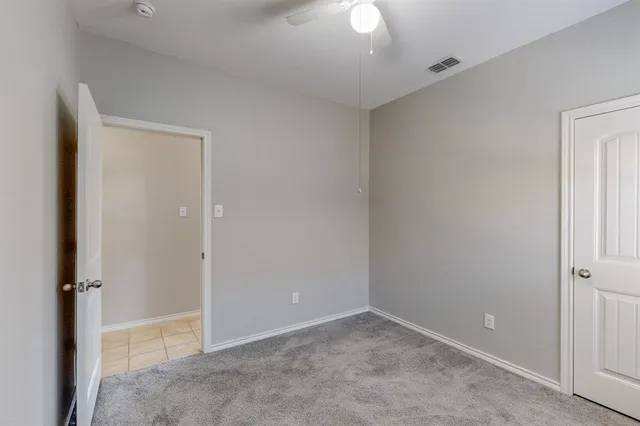 an empty room with a chandelier fan