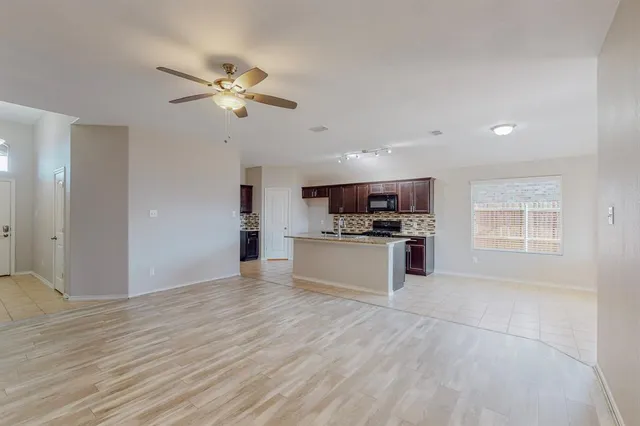 a kitchen with stainless steel appliances kitchen island granite countertop a stove a sink and a refrigerator