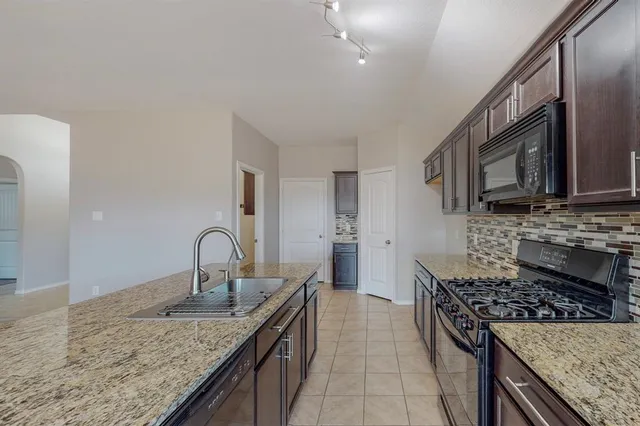 a kitchen with stainless steel appliances granite countertop a sink stove and cabinets