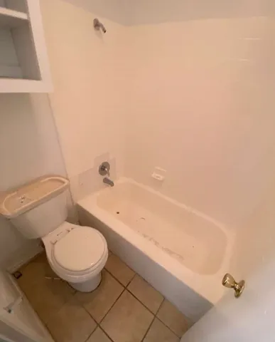 a white toilet sitting next to a bath tub