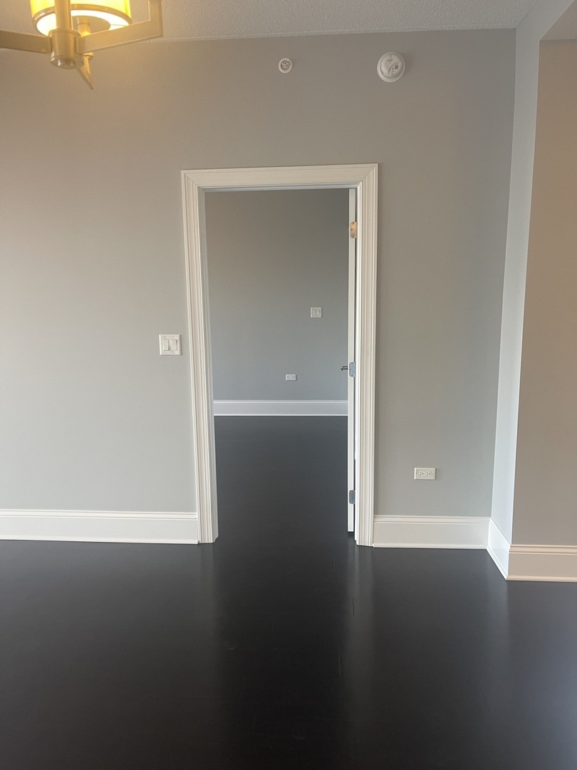 728 North Diamond Lake Road, Unit 211 Mundelein, IL 60060 - Photo 14 of 17 an empty room with wooden floor cabinet and windows