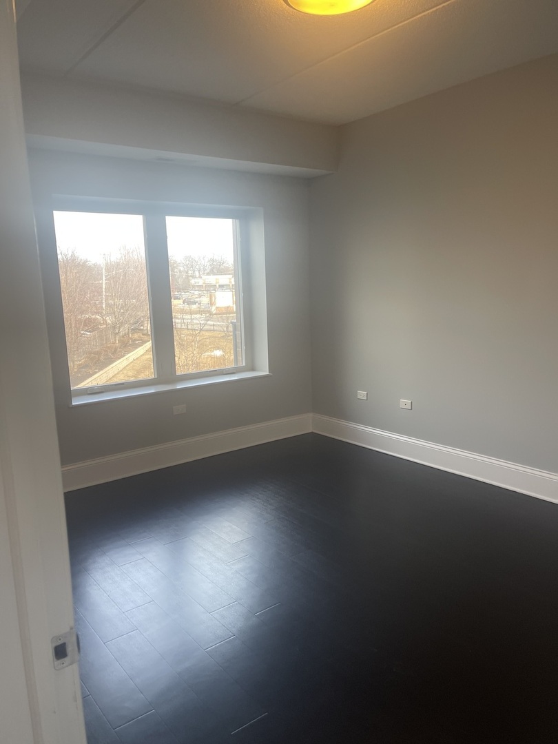 728 North Diamond Lake Road, Unit 211 Mundelein, IL 60060 - Photo 15 of 17 an empty room with wooden floor and windows