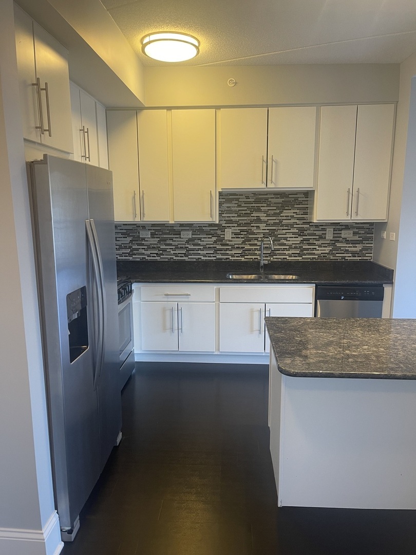 728 North Diamond Lake Road, Unit 211 Mundelein, IL 60060 - Photo 6 of 17 a kitchen with stainless steel appliances granite countertop a sink a refrigerator and a granite counter tops