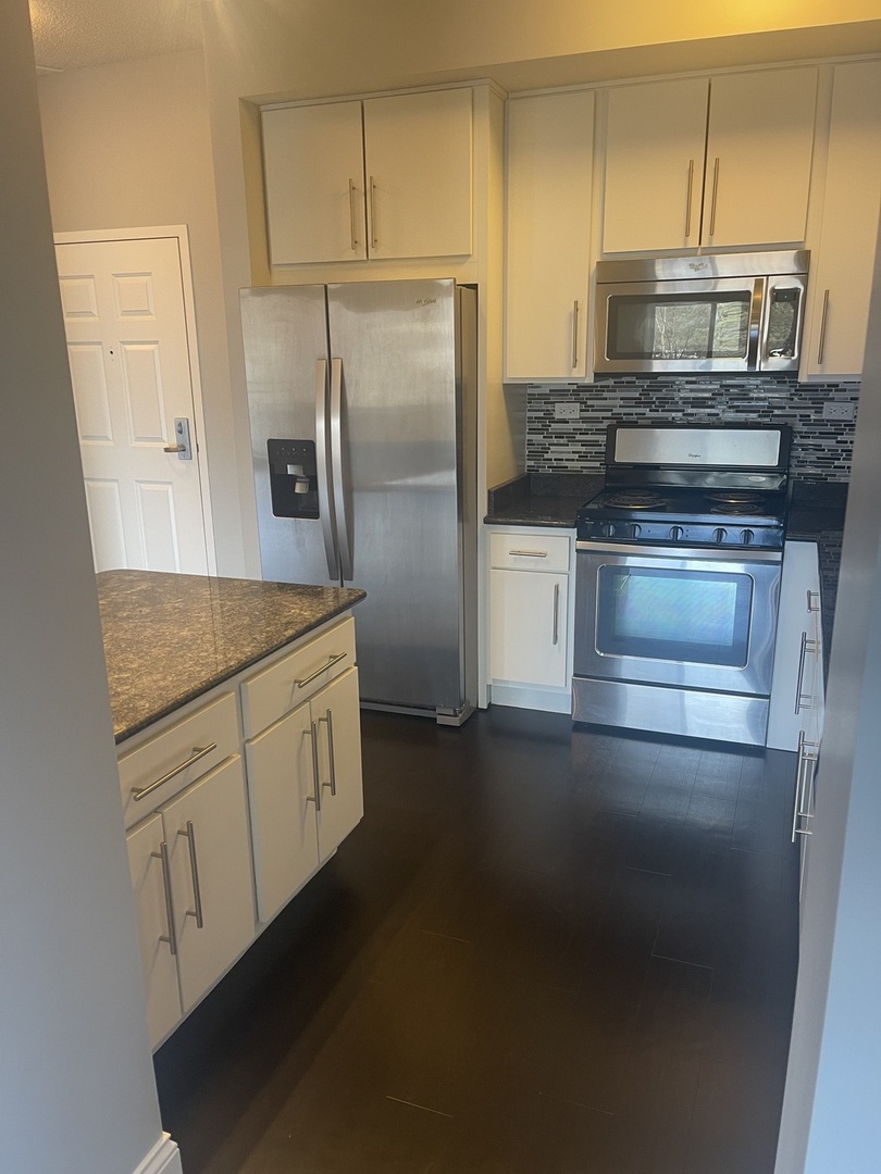 728 North Diamond Lake Road, Unit 211 Mundelein, IL 60060 - Photo 7 of 17 a kitchen with kitchen island a sink stove and refrigerator