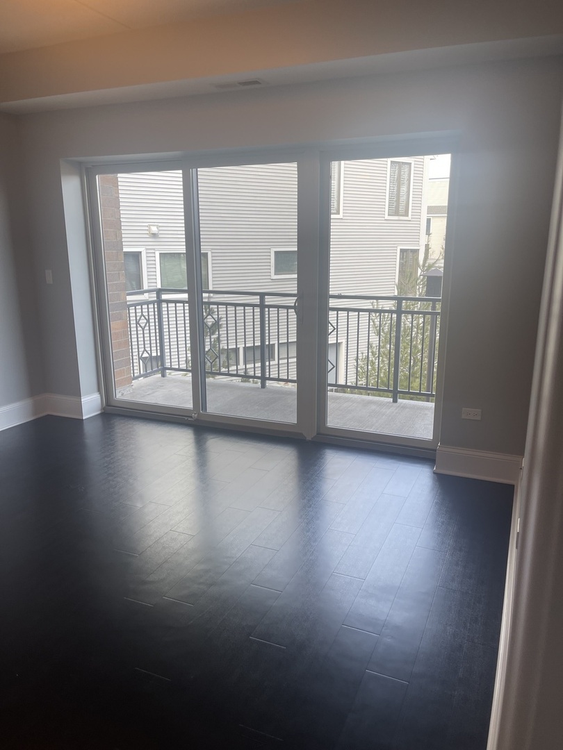 728 North Diamond Lake Road, Unit 211 Mundelein, IL 60060 - Photo 9 of 17 an empty room with wooden floor and windows