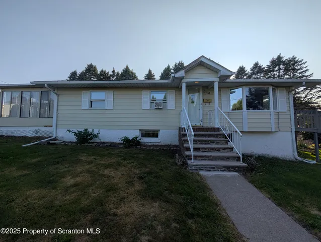 a front view of a house with a garden and plants