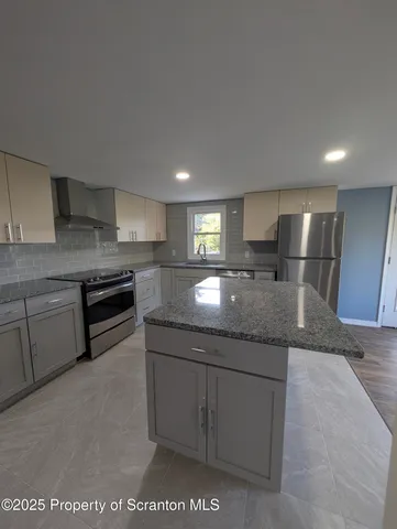 a kitchen with stainless steel appliances granite countertop a sink and a stove
