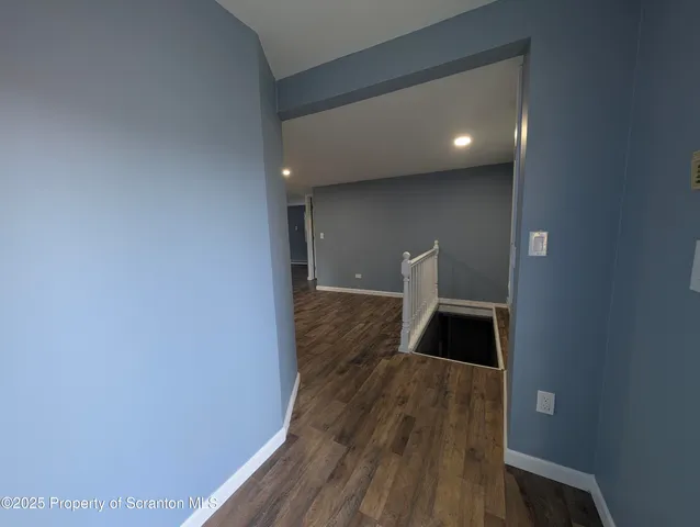 a view of an empty room and wooden floor