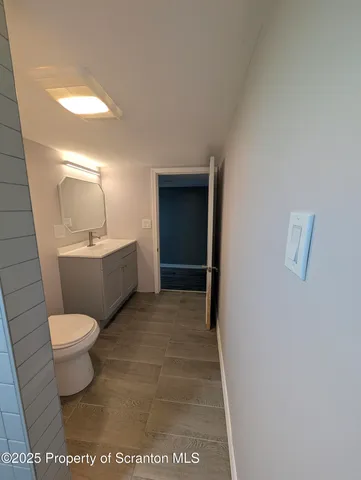 a bathroom with a toilet a sink and mirror