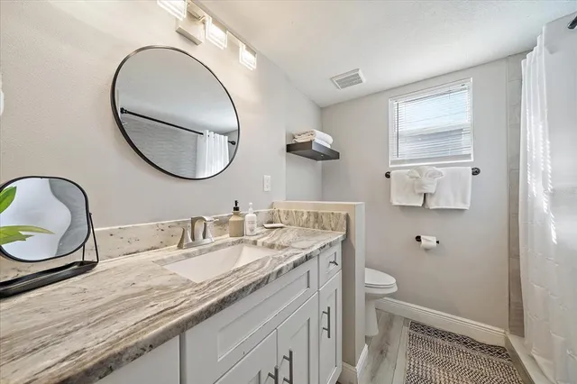 a bathroom with a granite countertop double vanity sink and a mirror
