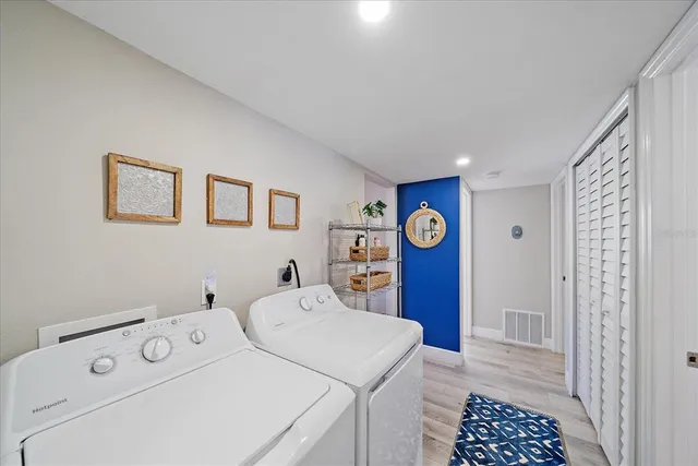 a view of washer and dryer with bathroom in the background
