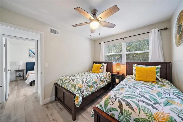 a bedroom with two beds and a large window