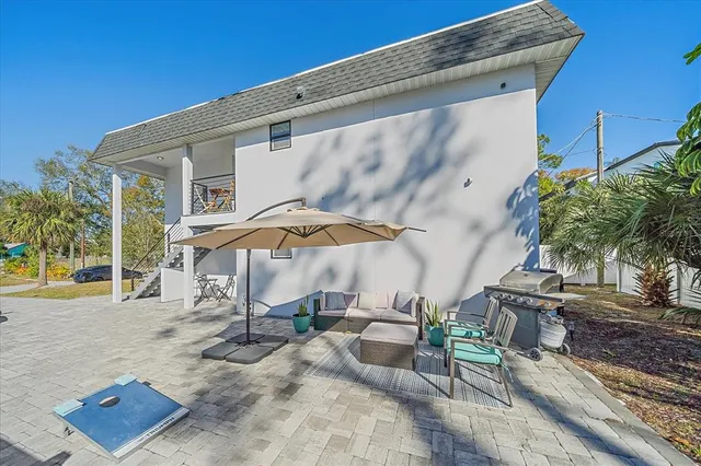 a patio with a table and chairs under an umbrella