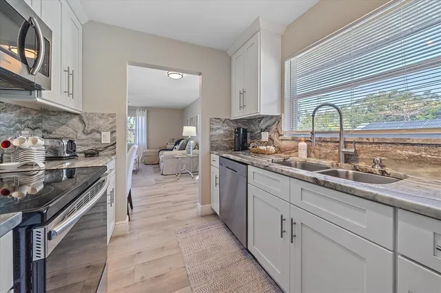 a kitchen with stainless steel appliances granite countertop a stove a sink and a microwave