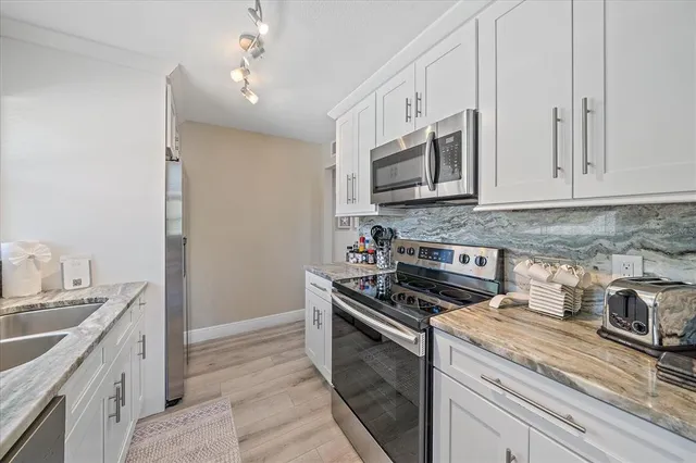 a kitchen with stainless steel appliances granite countertop a sink stove and microwave