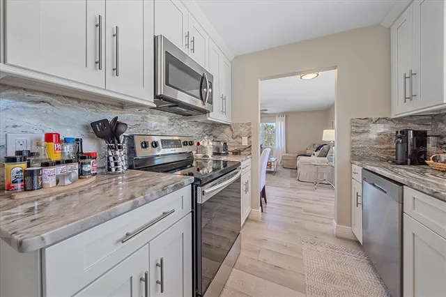a kitchen with stainless steel appliances granite countertop a stove microwave and cabinets