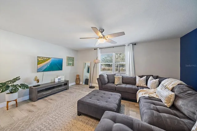 a living room with furniture a couch and a large window