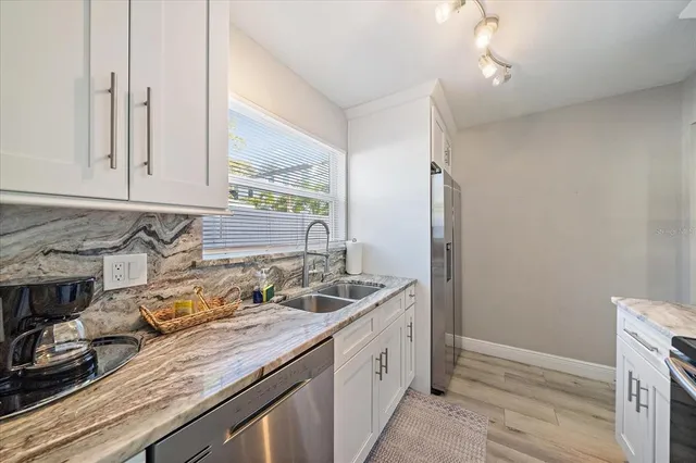 a kitchen with granite countertop a sink and a stove