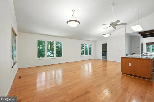 a view of an empty room with window and wooden floor