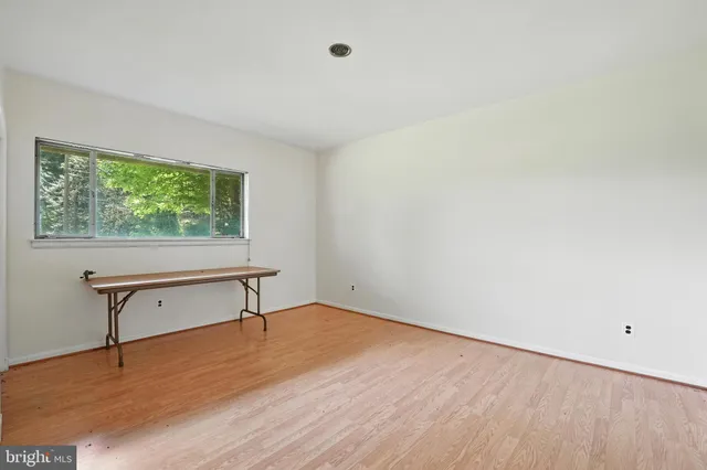 a view of a livingroom with wooden floor and a window