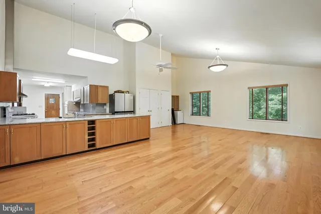a large kitchen with kitchen island a sink dishwasher stove and wooden floor