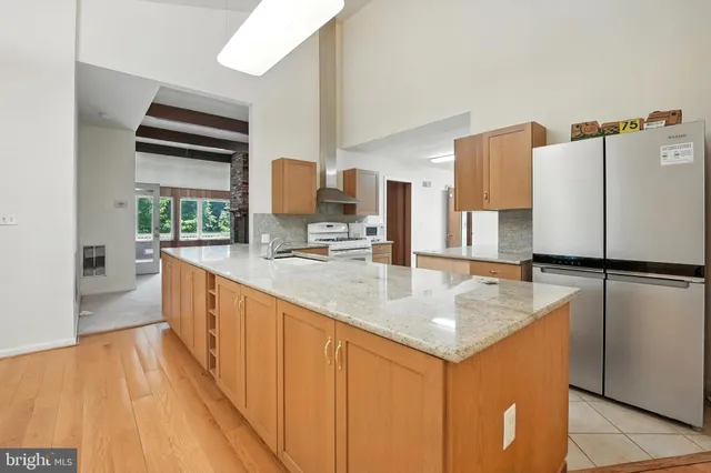 a kitchen with kitchen island a counter top space a sink a refrigerator and a stove