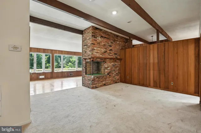 a view of an empty room with a fireplace and a window
