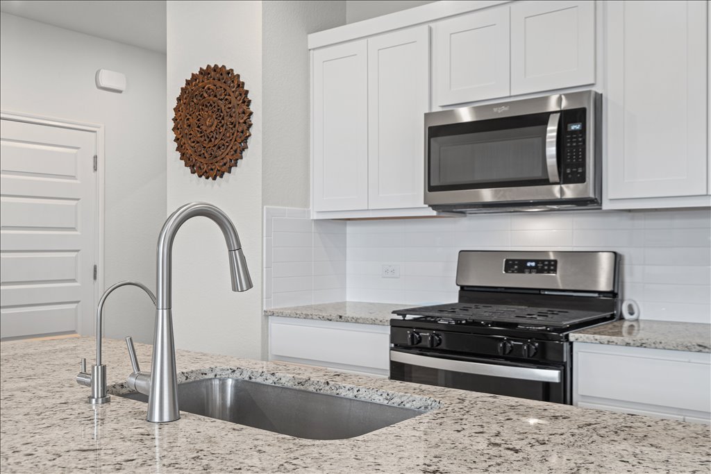158 Gullivers Drive Elgin, TX 78621 - Photo 8 of 36 You have a beautiful, clean white subway tile backsplash and stainless steel appliances, including a gas range and a built-in microwave.