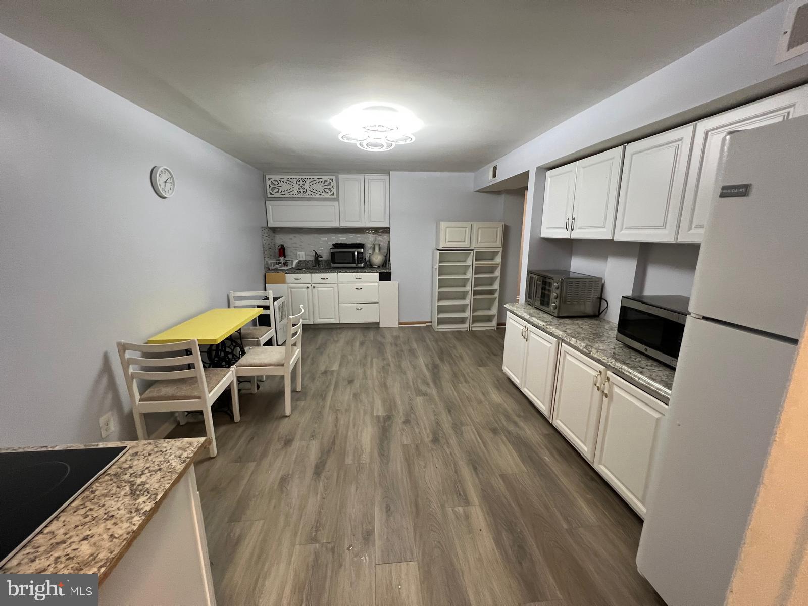 a kitchen with microwave a stove and chairs