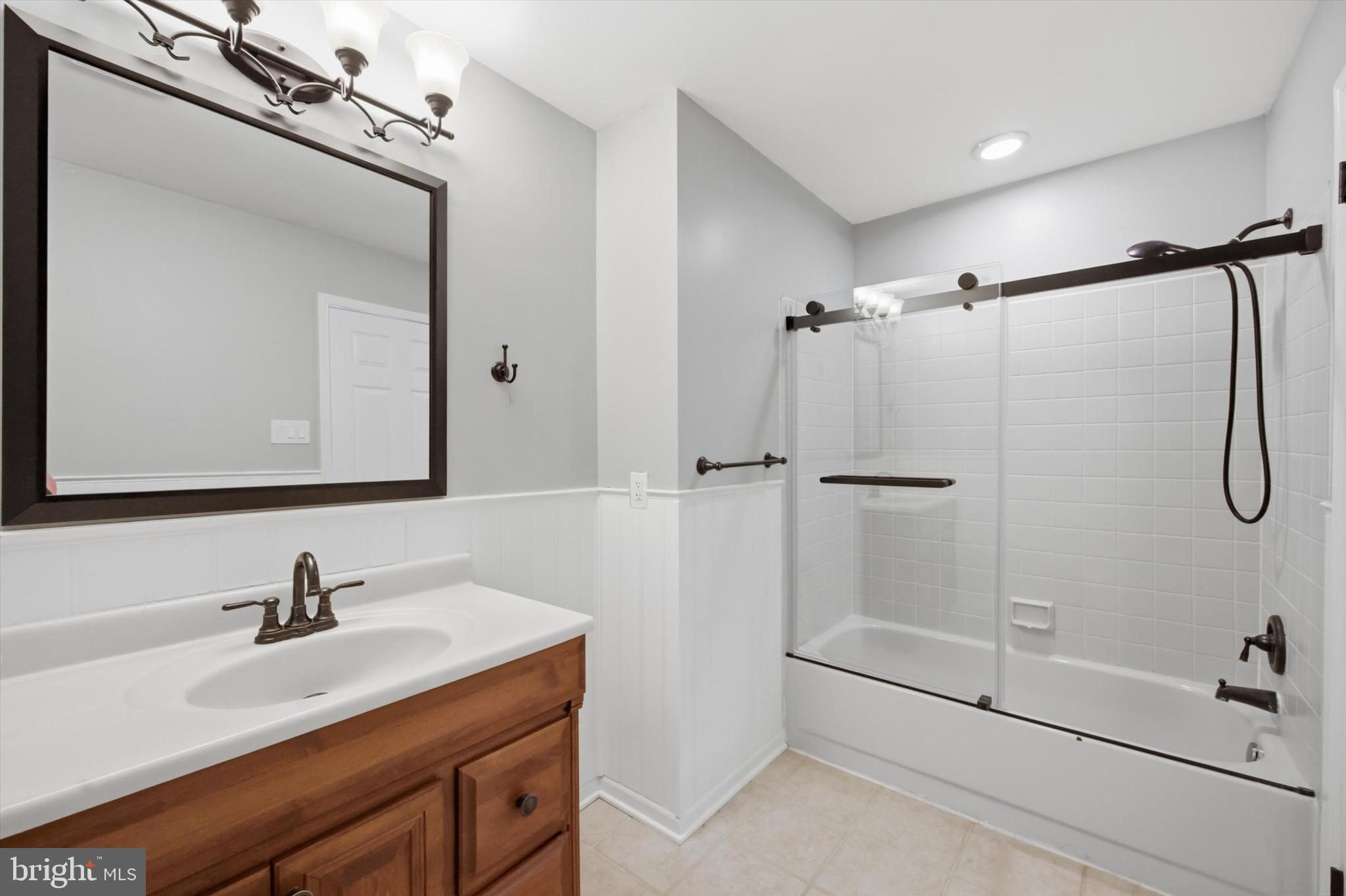 46 Main Street Chesterbrook, PA 19087 - Photo 32 of 44 a bathroom with a shower sink vanity and mirror
