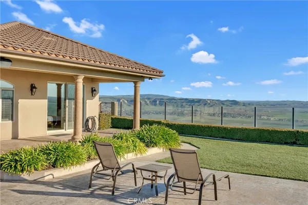 a view of a patio with a table and chairs under an umbrella