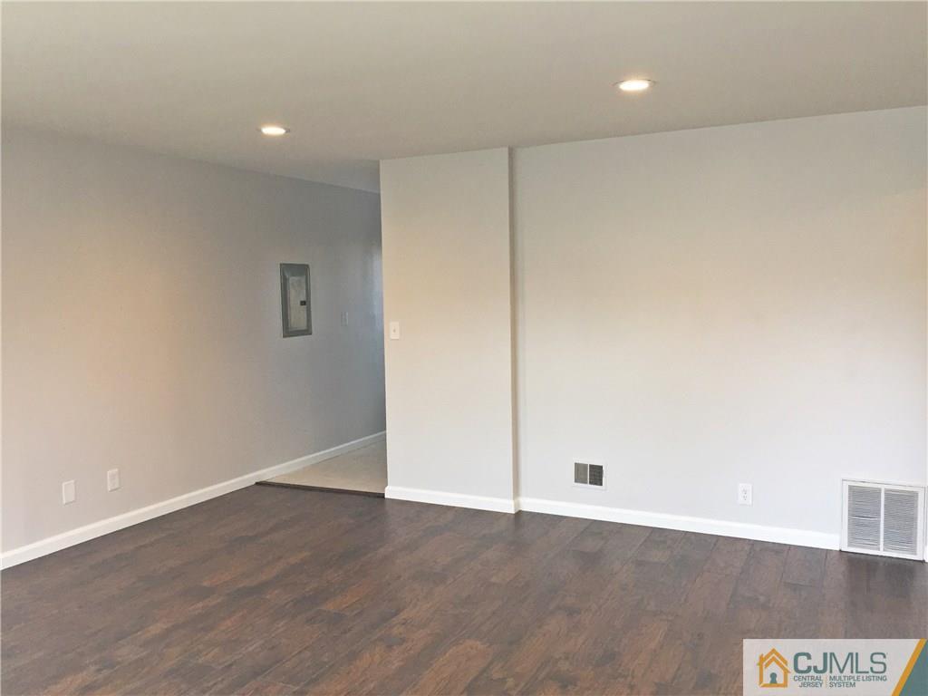 40 Parkerson Road Edison, NJ 08817 - Photo 6 of 11 an empty room with wooden floor and white walls