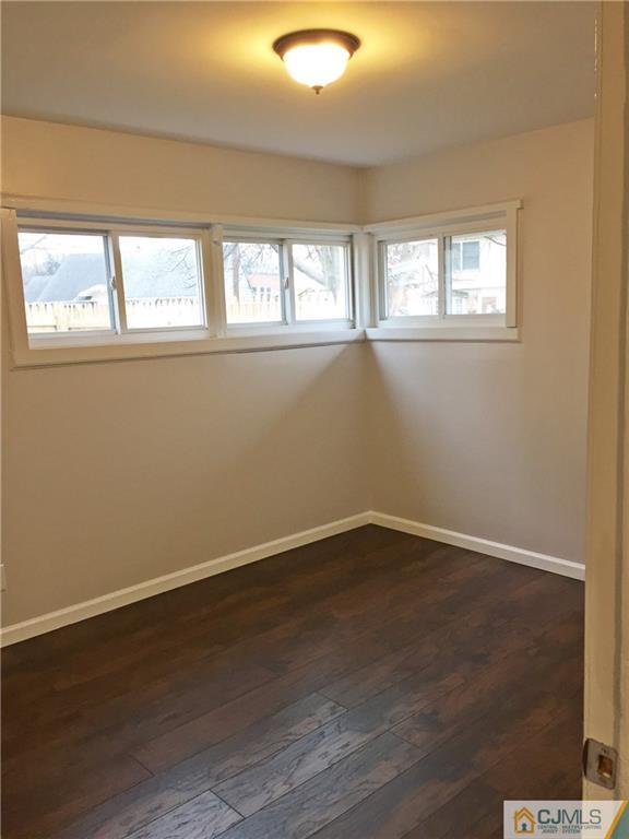 40 Parkerson Road Edison, NJ 08817 - Photo 8 of 11 an empty room with wooden floor and windows