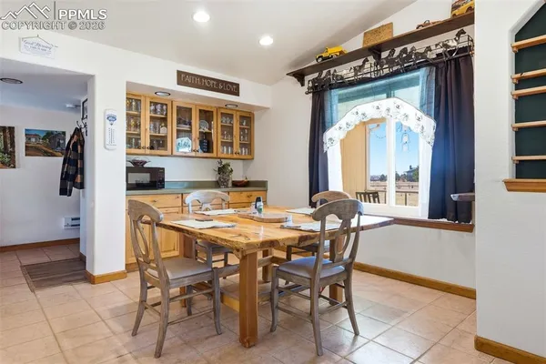 a dining room with furniture and a large window