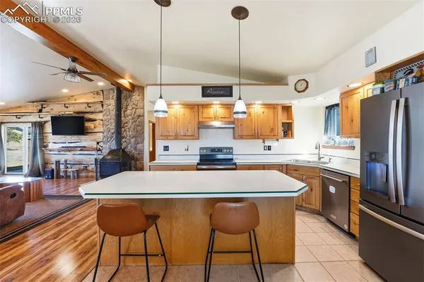 a kitchen with stainless steel appliances kitchen island granite countertop a sink a stove and a refrigerator
