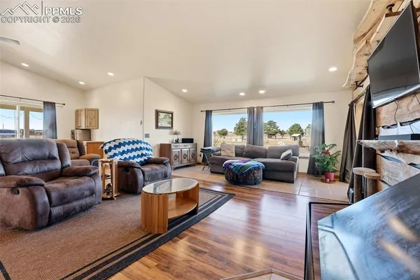 a living room with furniture kitchen view and a flat screen tv