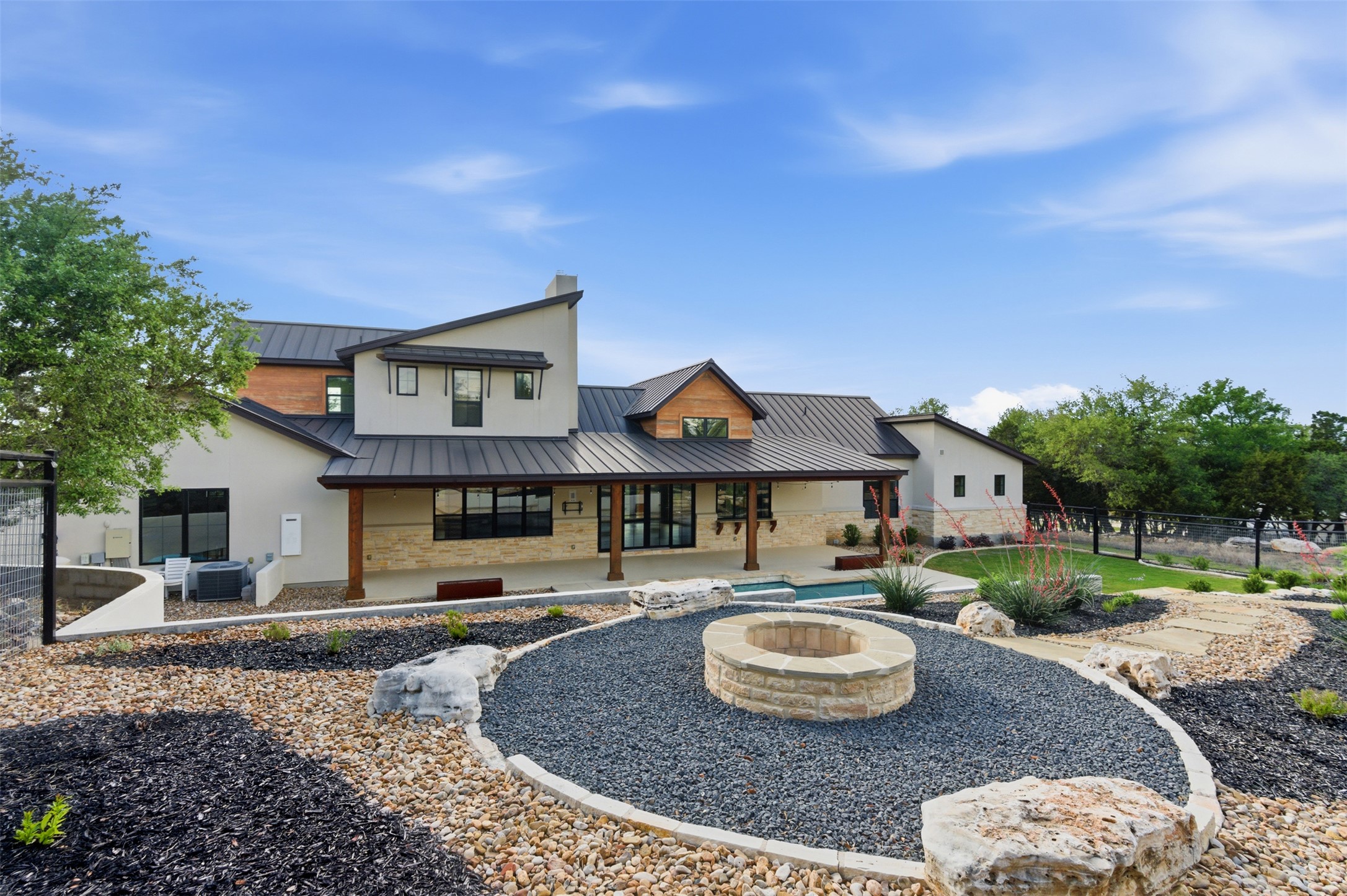 27619 Sunset Loop Garden Ridge, TX 78266 - Photo 28 of 39 A stone fire pit highlights the landscaped grounds of this modern multi-level estate.