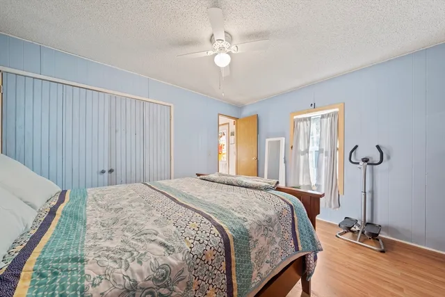 a bed sitting in a spacious bedroom next to a window