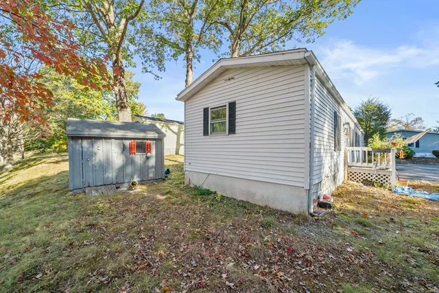 a view of a white house with a yard and a garden