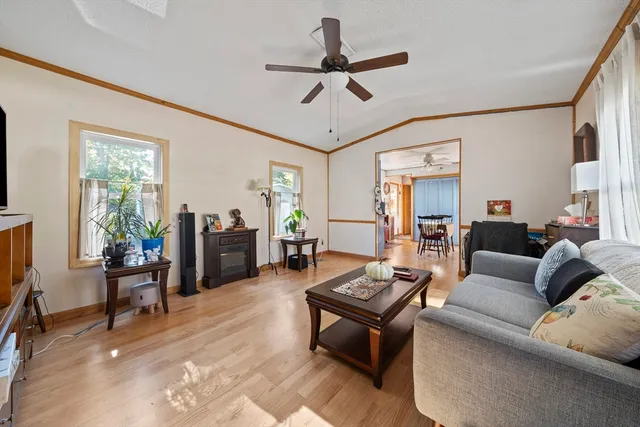 a living room with furniture a ceiling fan and a window