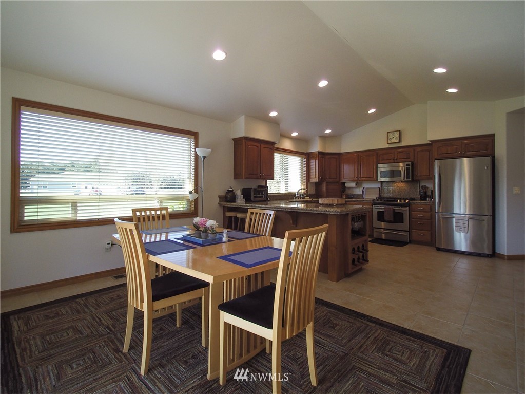 247 Jake Way Sequim, WA 98382 - Photo 12 of 40 a view of a dining room with furniture a kitchen and chandelier