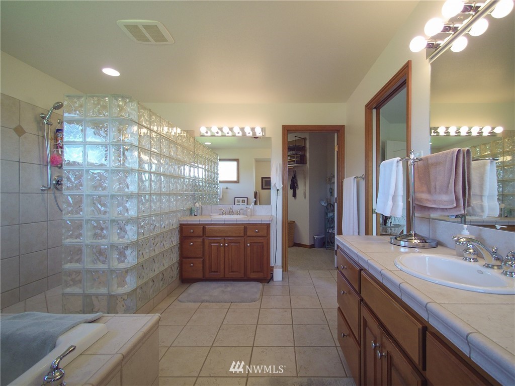 247 Jake Way Sequim, WA 98382 - Photo 26 of 40 a bathroom with a double vanity sink a toilet a mirror and shower