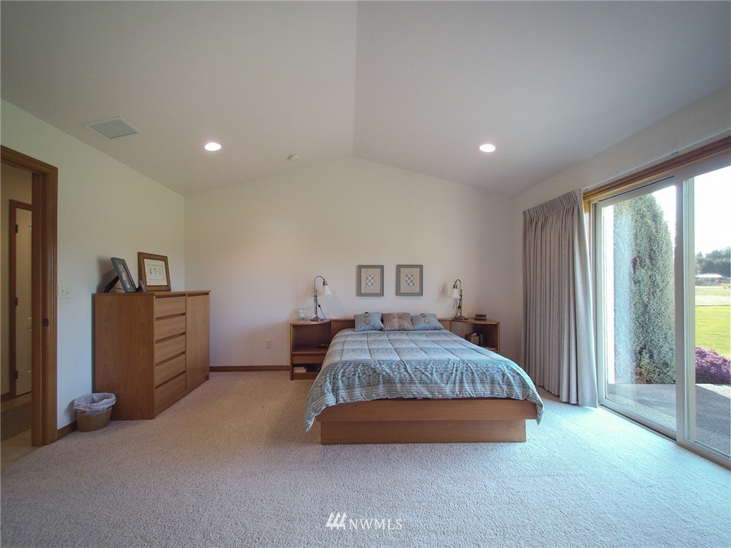 247 Jake Way Sequim, WA 98382 - Photo 28 of 40 a spacious bedroom with a bed and large windows