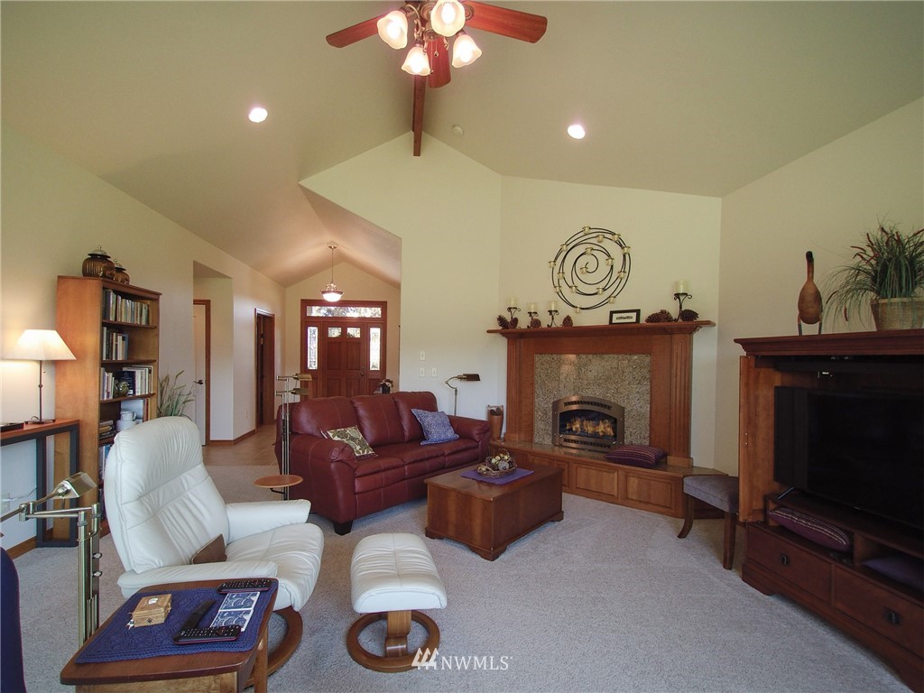 247 Jake Way Sequim, WA 98382 - Photo 5 of 40 a living room with furniture a fireplace and a chandelier