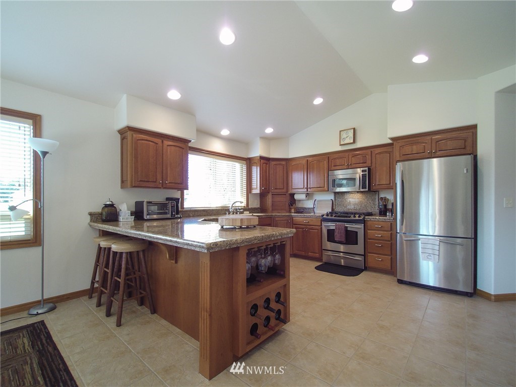 247 Jake Way Sequim, WA 98382 - Photo 9 of 40 a kitchen with refrigerator a microwave a sink and a stove
