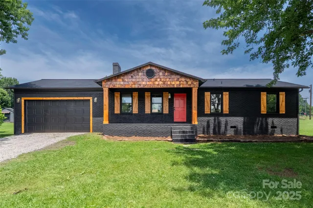 a front view of a house with a yard and trees