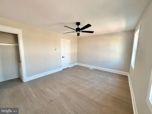 an empty room with a ceiling fan and a window