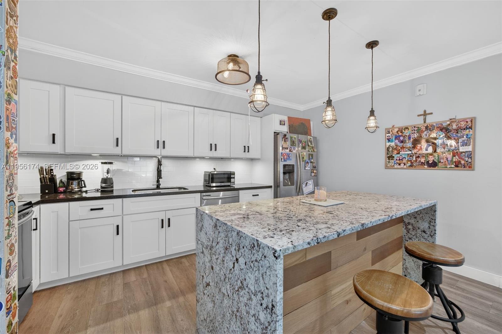 a kitchen with stainless steel appliances granite countertop a sink a refrigerator and a stove