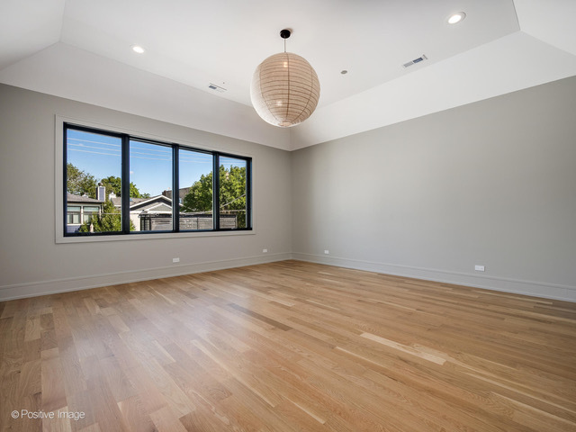 2214 West Oakdale Avenue Chicago, IL 60618 - Photo 6 of 15 an empty room with wooden floor and windows